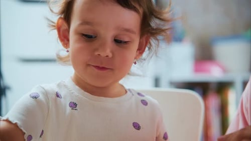 Toddler Girl Plays with Modeling Clay at Table