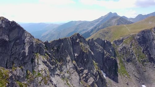 Romania’s Towering Mountains With Their Sharp Peaks, Lush Green Grass, And Winding Trails That Becko