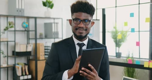 Close up portrait of african american businessman in glasses which posing on camera while working