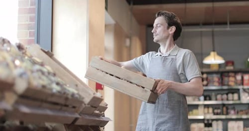 Small business owner of a food market stocking shelves