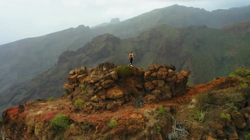 Woman Hiker Stands on Rugged Mountain Outcrop