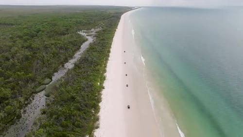 Aerial view of jeep on beach and ocean, Australia.