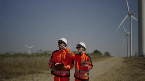 Engineers work at windmill farm.