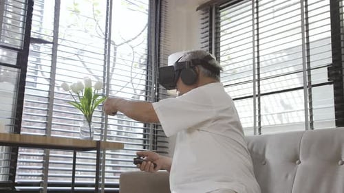 Senior Man Experiencing Virtual Reality Headset at Home
