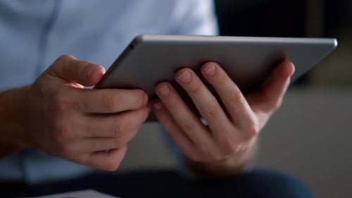 Business Man Hands Using Tablet Computer Surfing Internet in Home Office. Unrecognizable