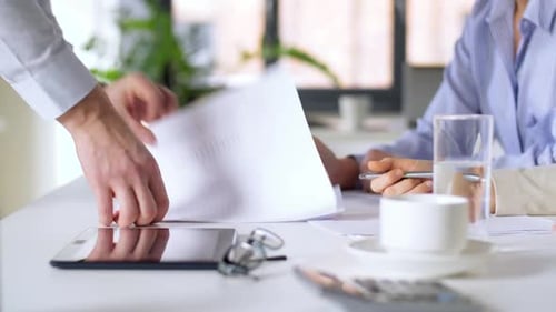 Businessman showing papers with charts to businesswomen at office
