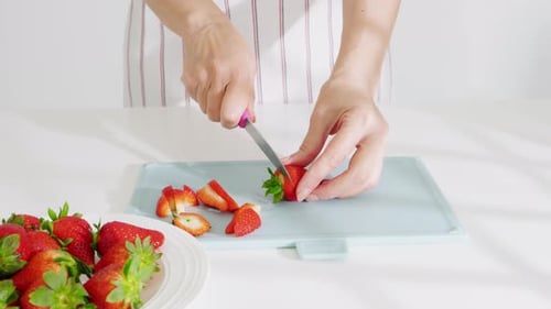Woman Cutting Fresh Strawberries on Cutting Board