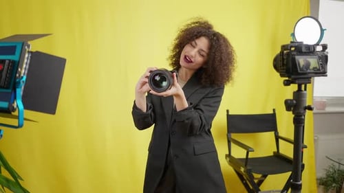 Stylish Woman Holding Camera Posing in Studio