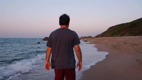 Einsamer Mann geht am Strand spazieren