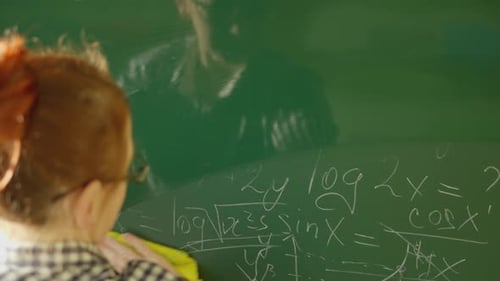 A Girl Student Writes on a Green Board