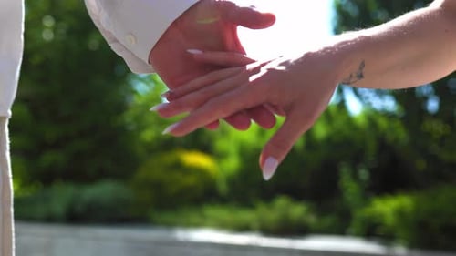Engaged Couple Holding Hands in a Sunny Park