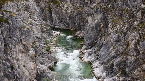Rapid mountain river flowing through deep canyon. Powerful stream in rocky gorge
