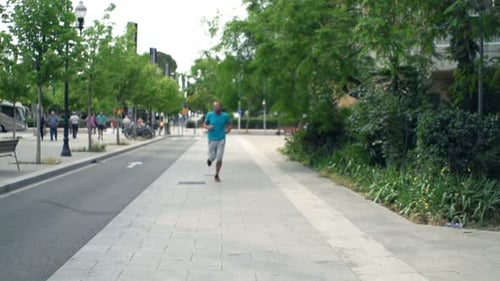 Young man jogging through the city streets on a sunny day for fitness