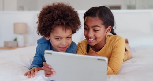 Children Enjoying Tablet Together on Bed
