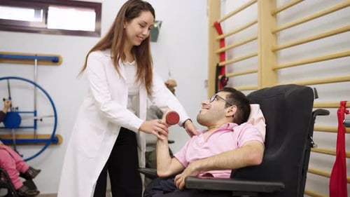 Therapist Assists Man with Exercise in Rehabilitation Facility