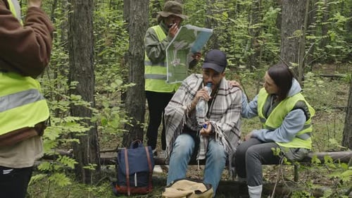Support Team Aids Man in Dense Forest