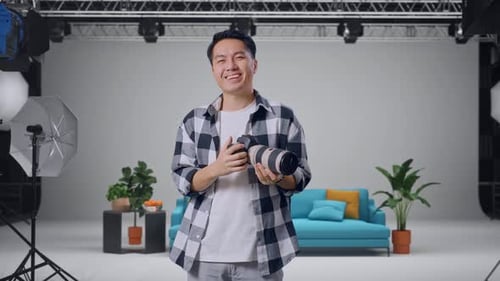 Asian Photographer Using A Camera Taking Pictures And Smiling In The Studio
