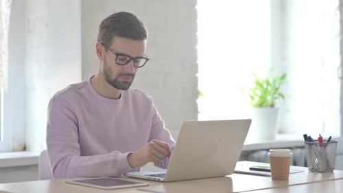 Man Working on Laptop Gives Thumbs Up