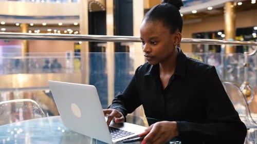 Un jeune professionnel travaille sur un ordinateur portable dans un environnement de travail moderne et élégant
