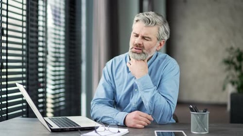 Man with Sore Throat at Office Desk