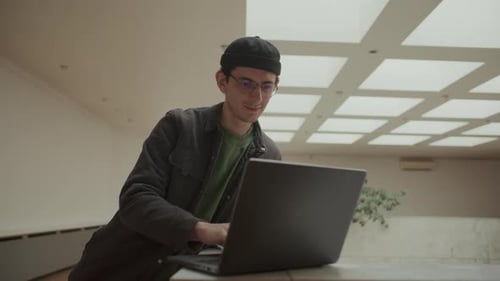 Young IT Professional Working on Laptop in Modern Office