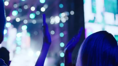 Enthusiastic Audience Applauds at Night Music Event