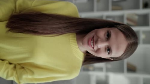 Vertical Video Smiling Brunette Girl Looking at the Camera Wearing Yellow Sweater