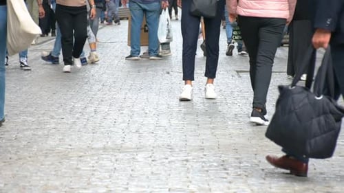 Concept crowd feet with shoes closeup. Anonymous people walking on the street. Legs of Crowd People