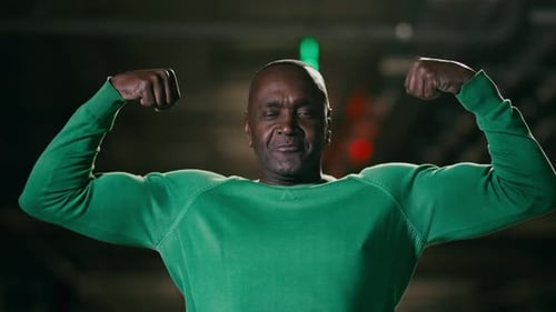 Reifer, starker, sportlicher lustiger Afroamerikaner, der Muskeln zeigt, selbstbewusster männlicher Athlet, Sportler