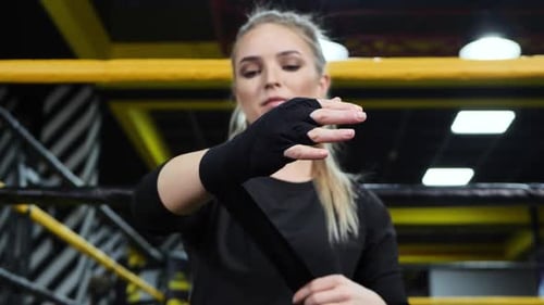 Woman Wrapping Hands with Boxing Wraps in Gym