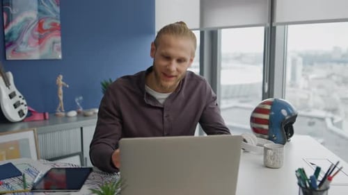 Annoyed businessman screaming at video call partner in modern workplace office