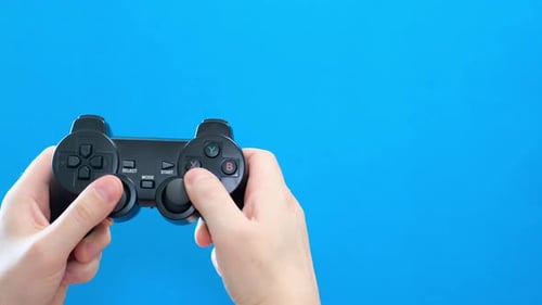 Hands Playing Video Game with Controller on Blue
