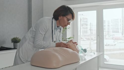 Doctor Demonstrating CPR Process To Students