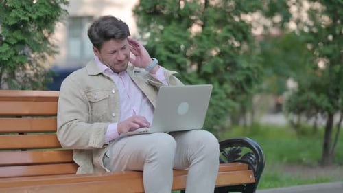 Adult Typing On Laptop Outdoors In Park