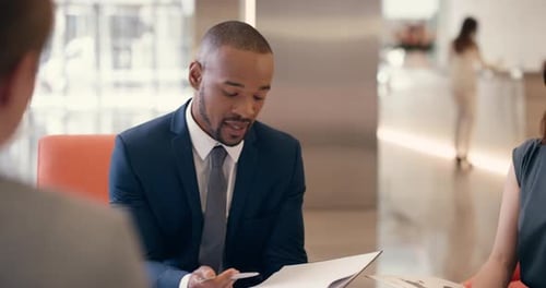 4k video footage of a group of businesspeople going through paperwork together in an office