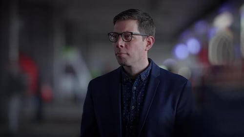 Man Standing Indoors Wearing Glasses and a Blazer