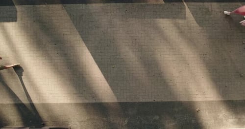 Luftaufnahme von zwei Personen, die auf einem gepflasterten Weg laufen
