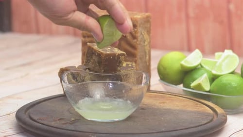 Hand Squeezing a Fresh Green Lime to Make Juice in a Bowl