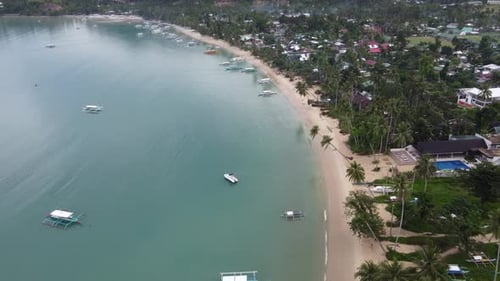 Tropical Beachfront of port barton seaside village with traditional boats at itaytay bay. Aerial