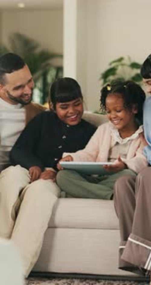 Happy, tablet and parents with kids on sofa for online videos, educational games and bonding