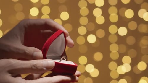 Closeup of Hands Opening a Red Box for Wedding Ring and Jewelry