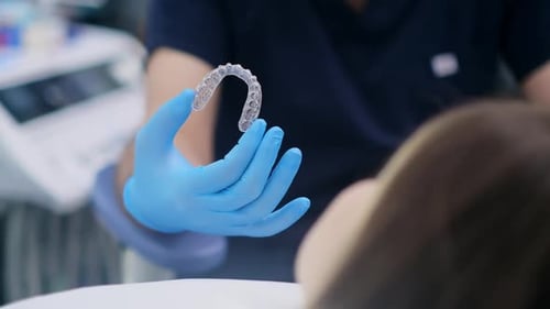 Professioneller Kieferorthopäde zeigt innovative Aligner vor der Kamera, die zur Bisskorrektur entwickelt wurden