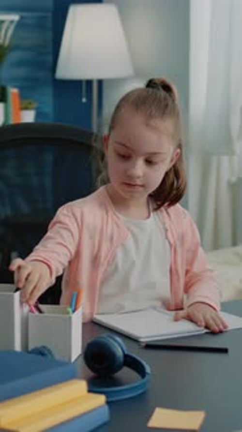 Vertical Video Schoolgirl Using Colorful Pencils to Draw on Notebook at Desk