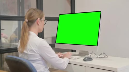 Young Woman Working on Computer with Green Screen