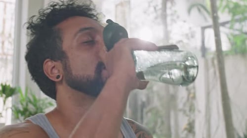 Man Drinking Water after Home Training