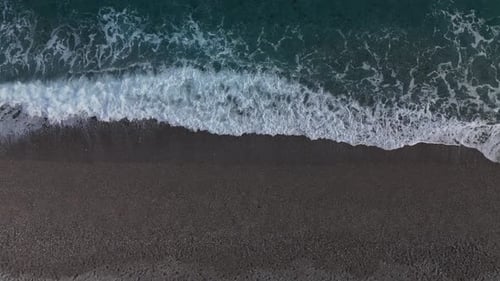 Aerial Drone View of Waves Gently Crashing on the Tranquil Sandy Beach