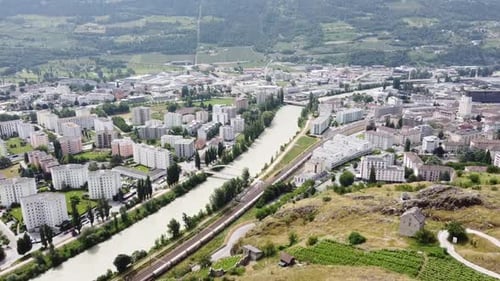 The river Rhone flows through sierre in valais (switzerland), sunny drone photo