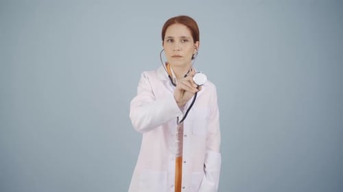 Woman Doctor Holding up Stethoscope in Lab Coat