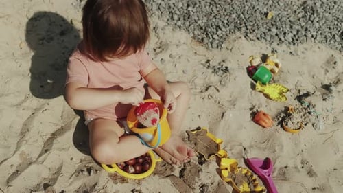 A Child Delightfully Playing with Colorful Toys on the Beautiful Beach During Summer