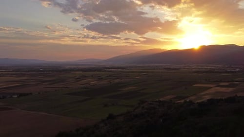Sunset over fields and mountains